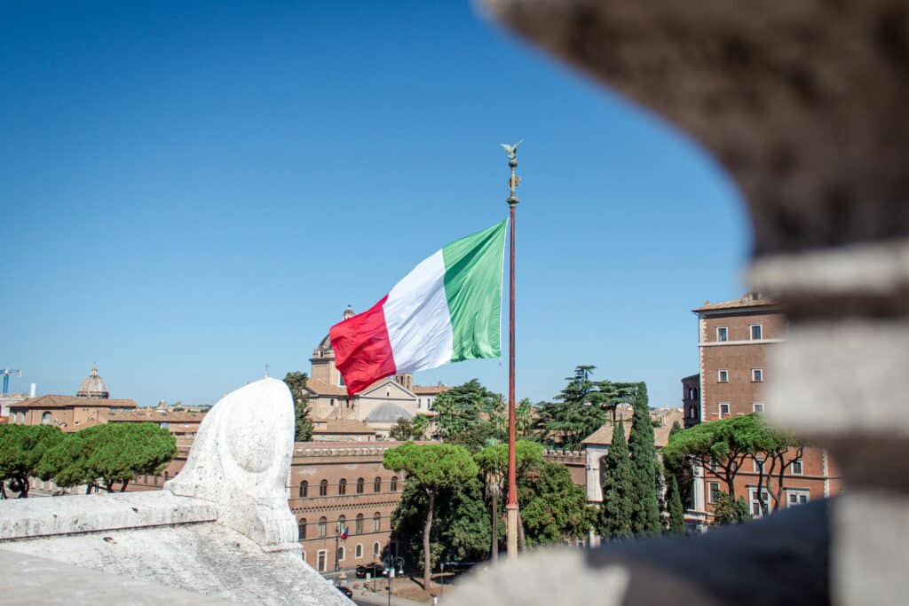 Flag of Italy in Rome, Italy; Italy is set to raise its flat tax for high-net-worth-residents amidst growing millionaire migration.